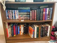Front view of laminate bookcase filled with DVDs, Harry Potter books, and assorted hardcover books.