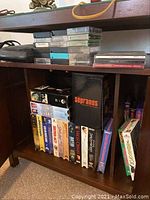 Shelf with assorted VHS tapes and boxed sets including The Sopranos, Titanic, Sister Act, The Godfather