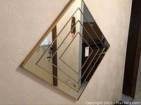 Front view of the square mirror showing the layered inset mirror panels in a stepped design and gold frame.