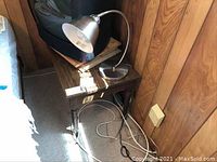 Overall view showing composite wood table with brushed stainless steel goose neck lamp placed on top.