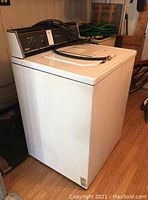 Full view of white RCA top load washing machine showing exterior and shape