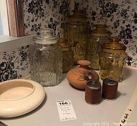 View of all glass canisters, ceramic dish, ceramic vase, and salt and pepper shakers