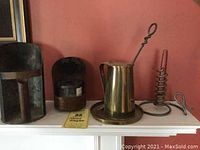 Overall view of colonial fireplace smalls on mantel including Cape Cod fire starter, courting candle, and tin candle luminaries
