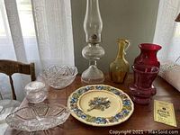View of all items on table showing oil lamp, two vases, Crown Ducal plate, and bowls