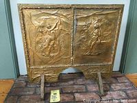 Full front view of the fireback showing both panels with classical figures and decorative border.