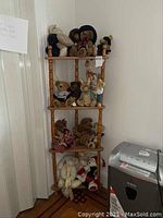 Wooden corner shelf with teddy bears and other stuffed animals displayed across four shelves in room corner.