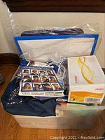 Plastic storage bin with crafting supplies including Brother craft kit box and bags