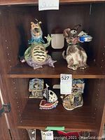 Wider shot of shelf with multiple Blue Sky votives in animal and themed styles.
