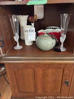 Shelf containing two Sasaki crystal frosted stem vases, white Teleflora vase, Asian green lidded bowl, and two Lenox vases (white scalloped, red and white).