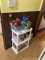 Plastic shelving unit with kitchen items on and around it.