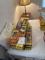 Stack of yellow Rail King boxes on bed next to lamp