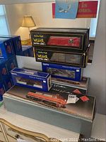 Stack of boxed freight car models including two Weaver Ultra Line boxes and two Products for Model Railroaders boxes