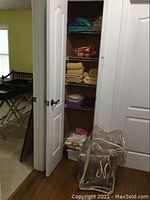 View of closet showing multiple shelves with folded linens and towels along with sealed pillow bags in front