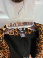 Photo of leopard print coat label and upper interior showing INC International Concepts brand, size Large.