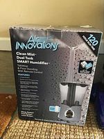 Front of the humidifier box showing brand, product name, key features like 120 hours run time, tabletop and floor standing use, remote control, and large water tank capacity.