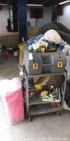 Photo showing the entire lot including toolbox on a cart with various tools and accessories around.