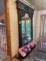 Full left-side view showing overall height, carved frame and planter with floral display