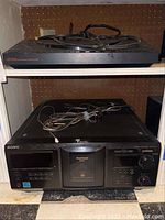 Shelf view showing Carrera turntable on top shelf and Sony multichanger on bottom shelf with cables