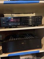 Both units stacked on shelving: CD player above amplifier