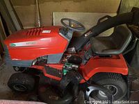 Side view of entire mower showing deck and leaf vacuum hose