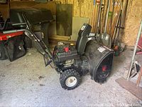 Side view of black Yard Machines snow blower showing engine housing and auger intake