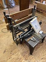 Folding work bench frame with attached wooden panels, showing the metal frame and folding mechanism.