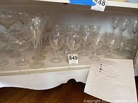 Varied Orrefors crystal glasses arranged on lower shelf showing multiple stemware types