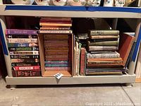 Wide shot of the lower shelf showcasing a range of books and VHS tapes packed closely together.