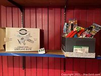 Shelf displaying the Tighar airplane bank box alongside a box full of assorted Pez dispensers, some still in packaging, others opened.