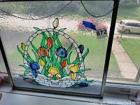 Window hanging stained glass art piece showing front view with floral basket design in multiple colors.