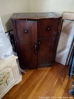 Front view of vintage wooden bar cabinet with closed doors.