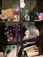Photo of shelving unit with decorative glass bottles, snow globe, basket, stapler, and office supplies