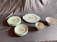 Full set of Paragon Rockery fine china arranged on gray cloth background showing plates, tea cup, and bowl.