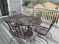 Patio table with four matching chairs assembled on deck