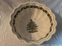 Top view of large white ceramic bowl showing Christmas tree design in center and holly border around rim.