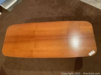 Top view showing table surface with warm brown wood finish, rounded edges