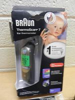 Boxed Braun ThermoScan 7 ear thermometer showing front packaging with baby image and product details.