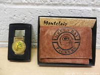 Photo showing the Green Bay Packers gold-tone money clip and the brown leather wallet with Green Bay Packers helmet logo in a Montclair branded box.