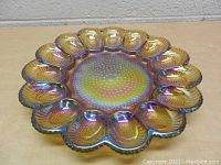 Top-down view of the carnival glass deviled egg dish showing twelve egg-shaped wells and the textured center.