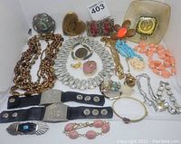Full assortment of the jewelry lot including necklaces, bracelets, rings, pins, and the gold heart compact.