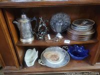 Photo showing Rodgers quadruple teapot, metal candle holder, decorative hooks, small metal pitcher, collectible plates including blue and white bowls, and aluminum with porcelain serving dish.