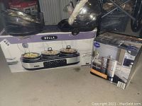Bella triple slow cooker in box with visible controls and three pots with lids