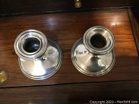Top view of the interior holder of two silver candlesticks showing circular shape and polished silver surface.