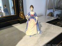 Front view of Royal Doulton Valerie figurine in blue and cream dress with pink bow.