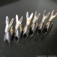 Six silver plated burro figurine cardholders lined up on a surface, showing their shape and design