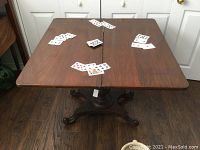Full view of the games table with the square top open and cards on the surface.