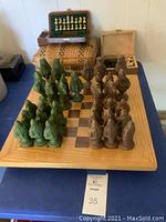 Full view of ceramic chess pieces arranged on wood inlaid chessboard