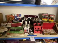 Wide view of the entire collection showing cards, poker chips, dominoes, and score pads on table