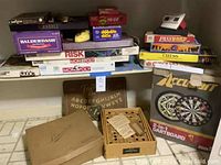 Photo showing the main assortment of boxed vintage board games including Labyrinth, Talking Board, Password, Ouija Board, Risk Monopoly, Chess, and dartboard set.