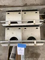 Front view of metal Purple Martin bird house with two compartments and multiple entry holes, showing protective metal frame and mounting pole attached.